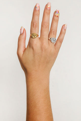 close-up-image-of-a-hand-with-painted-nails-wearing-gold-rings-including-that-of-the-spell-s-stargazer-zodiac-ring