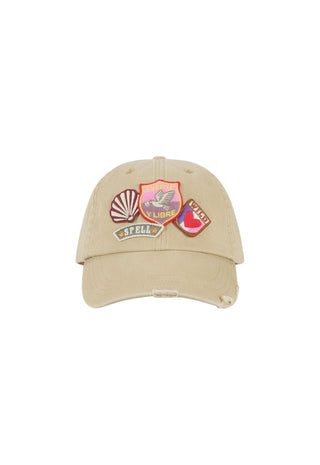a-beige-distressed-baseball-cap-featuring-three-colorful-embroidered-patches-on-the-front-set-against-a-plain-white-background