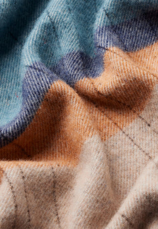 a-close-up-of-a-soft-woven-textile-with-a-plaid-pattern-in-muted-blue-peach-and-warm-beige-tones